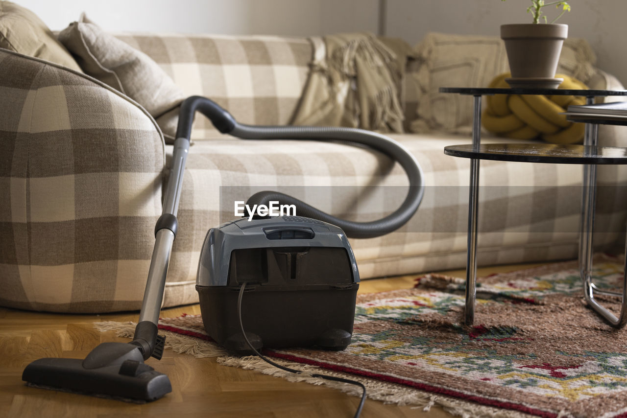 Old-fashioned vacuum cleaner in living room