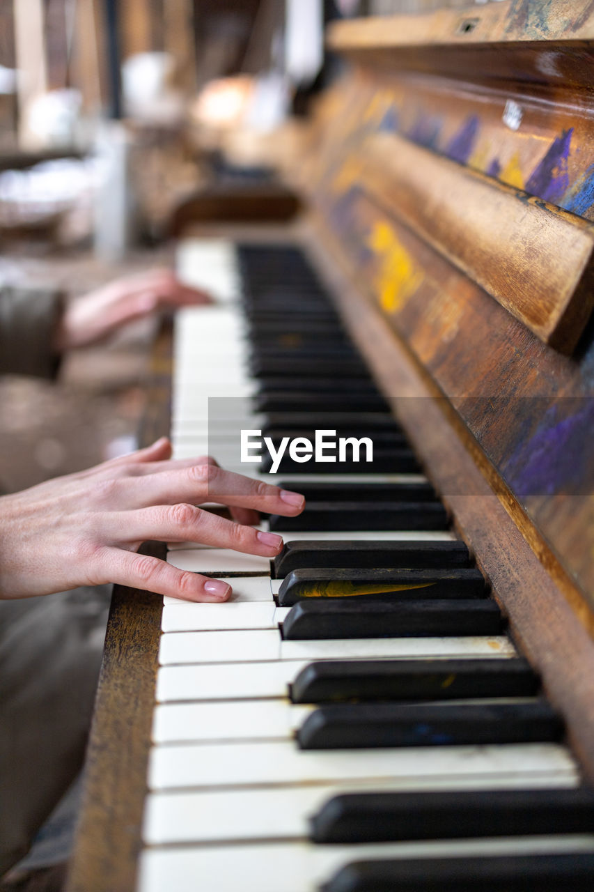 Cropped hand of woman playing piano