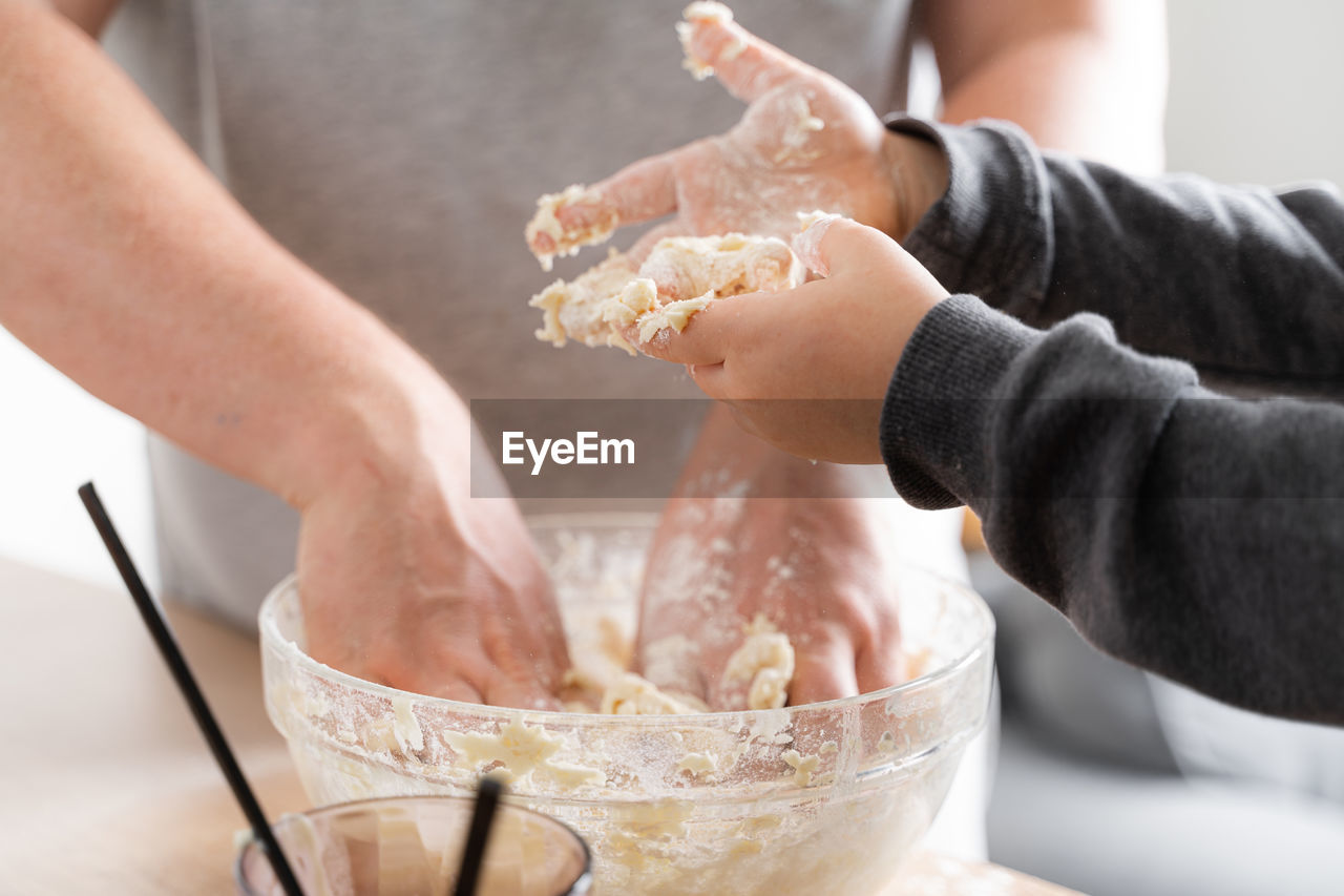 hand, food and drink, food, adult, indoors, baked, holding, midsection, men, women, close-up, dough, freshness, one person, domestic room, preparing food, domestic life, bowl, lifestyles, cooking, flour, kitchen, female, sweet food, kitchen utensil, making, mixing