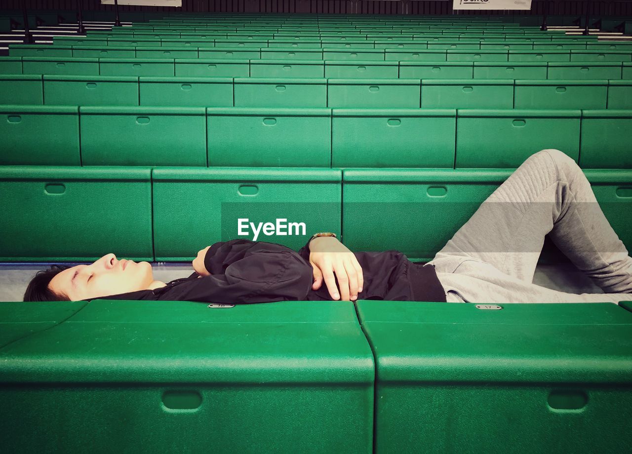 Man sleeping on green seat