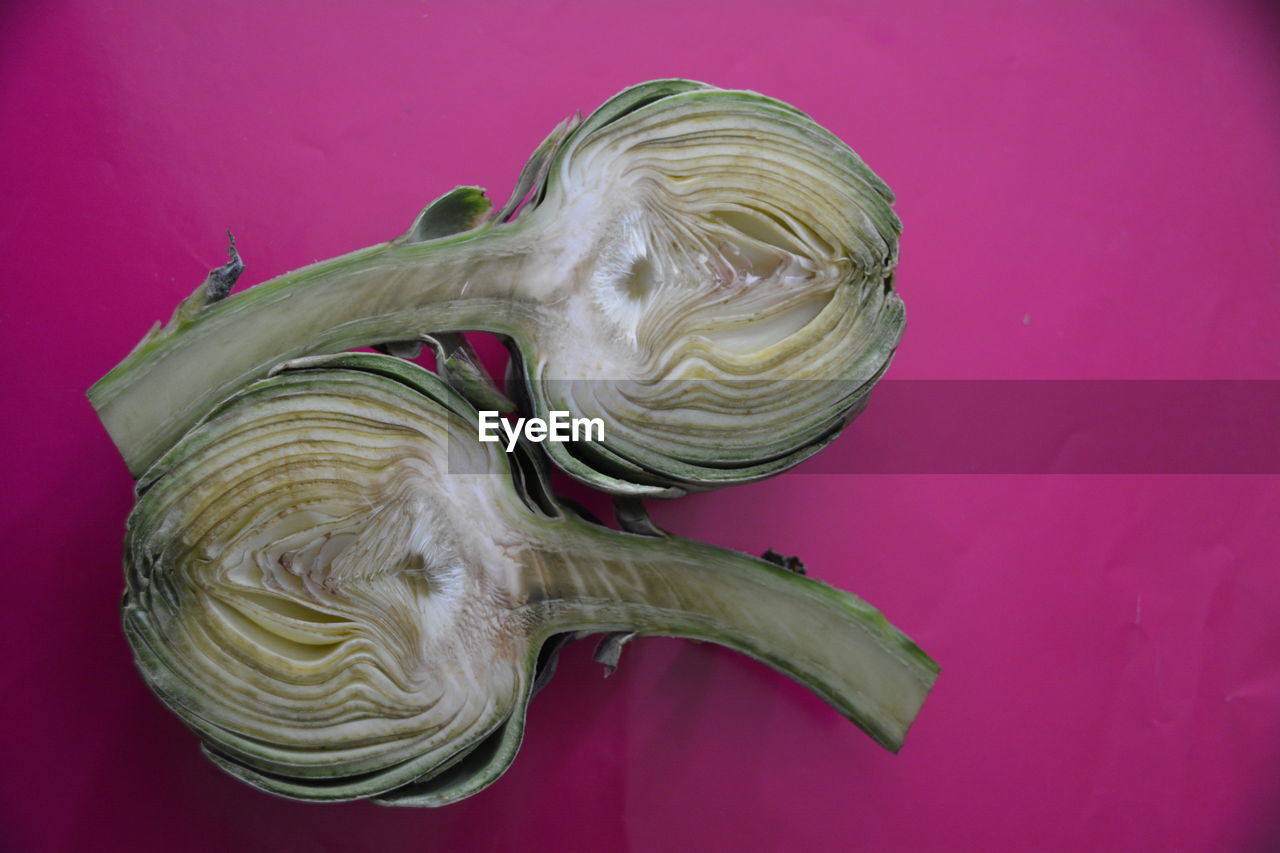 Close-up of sliced artichoke on pink background