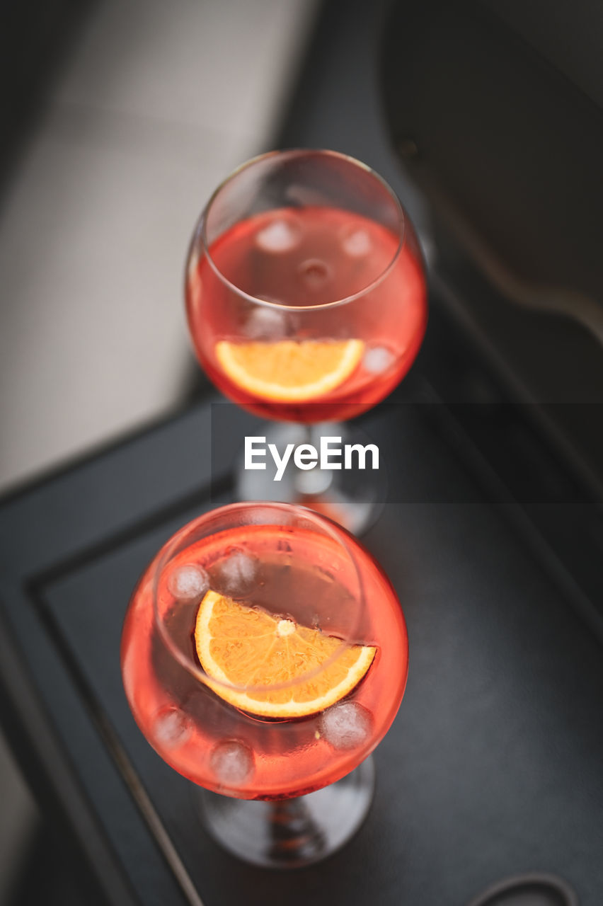 food and drink, refreshment, drink, glass, red, alcohol, household equipment, no people, indoors, high angle view, drinking glass, close-up, wine, food, alcoholic beverage, lighting, wine glass, freshness, orange color, rose wine, directly above
