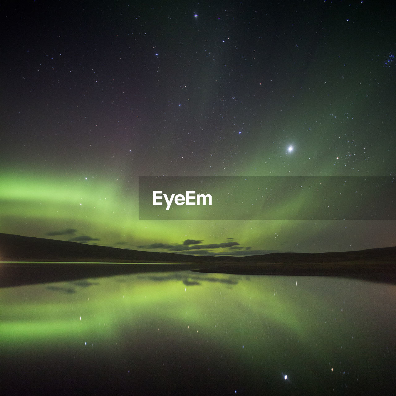 Scenic view of lake against sky at night