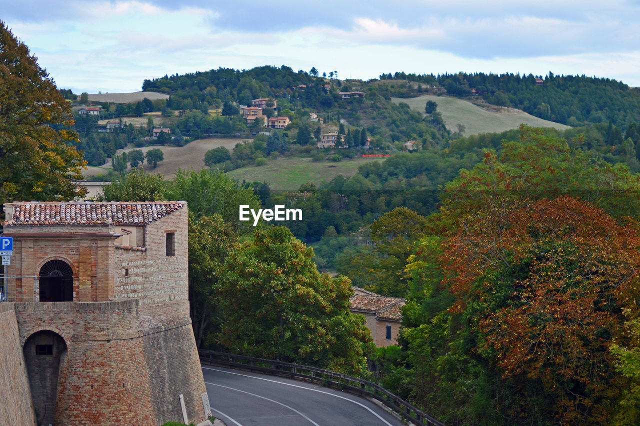 Built structure on road by buildings against sky