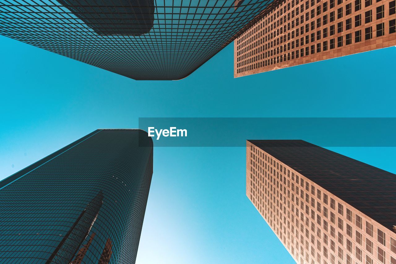 Low angle view of modern buildings against blue sky