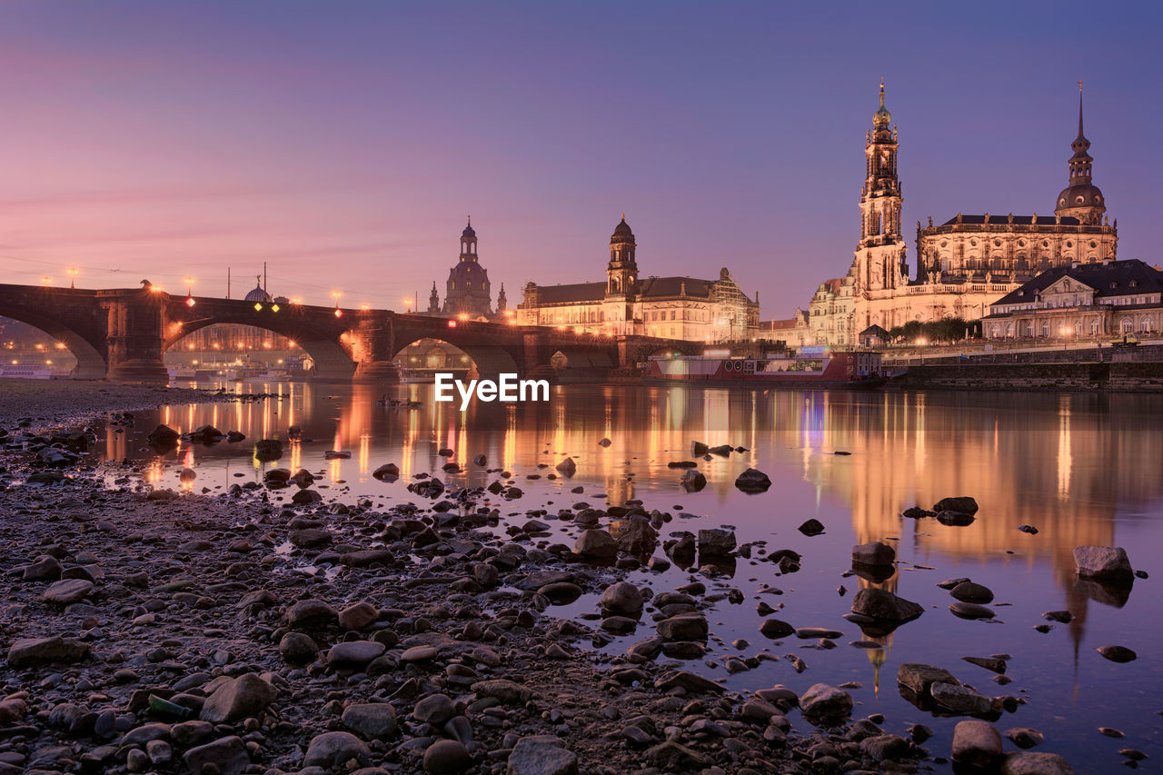 Elbe river against illuminated buildings in city