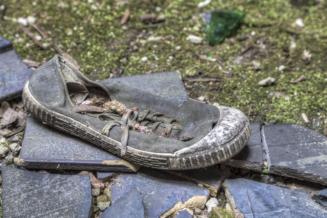 CLOSE-UP OF SHOES ON ABANDONED WATER
