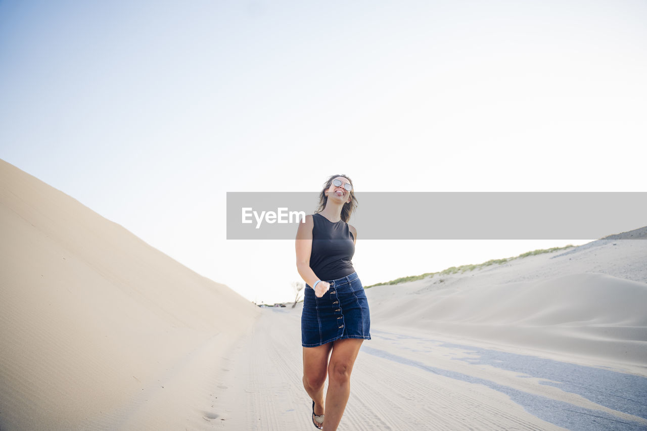 Young woman walking along the dunes