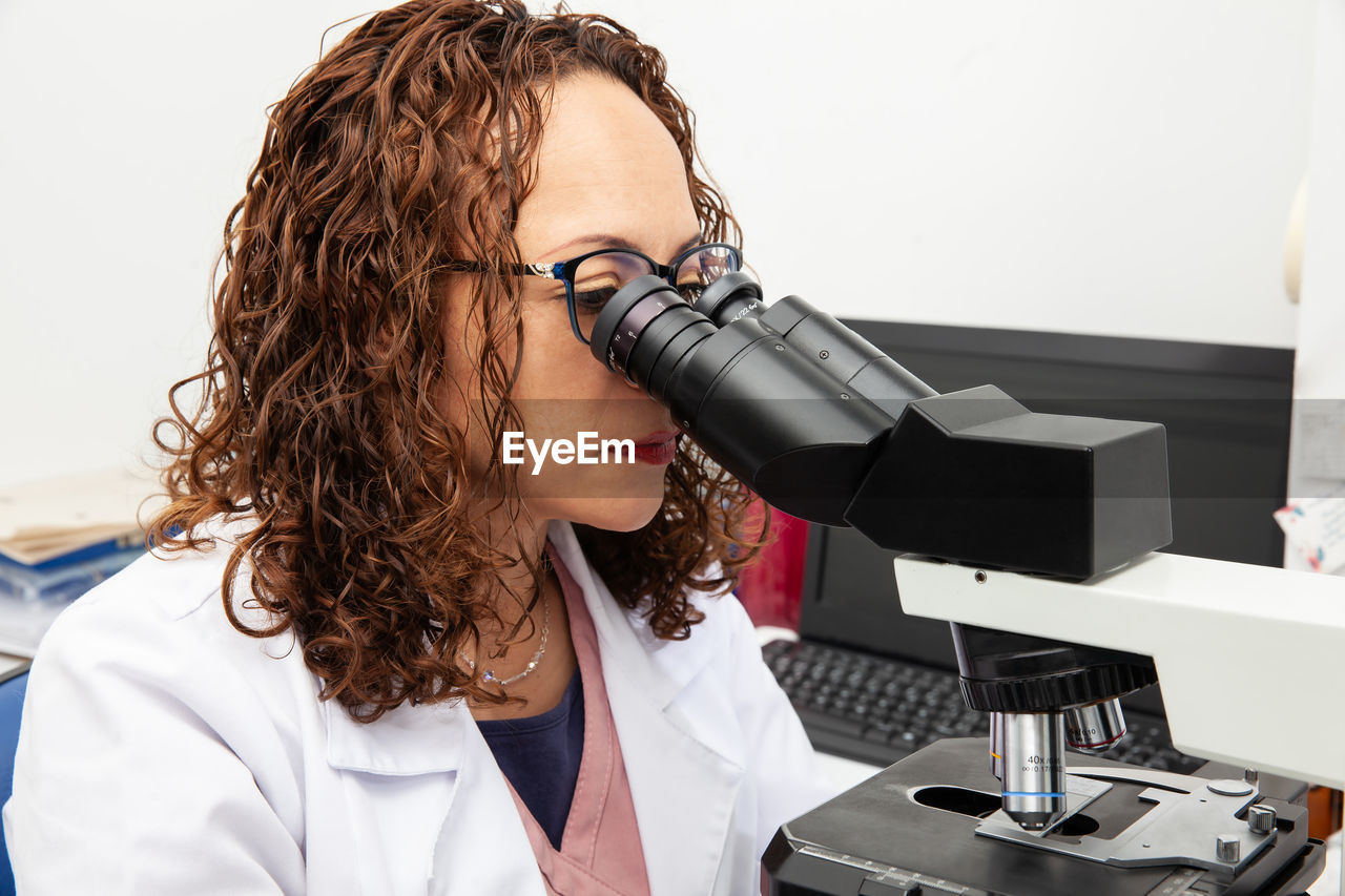 Cytologist looking at pap smear samples through a microscope. medical analysis concept.