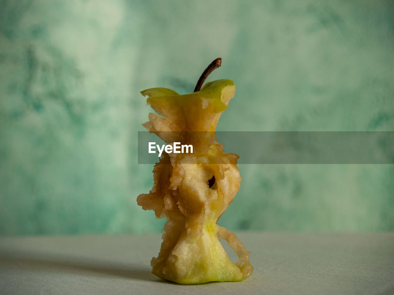 CLOSE-UP OF APPLE AGAINST BLUE BACKGROUND