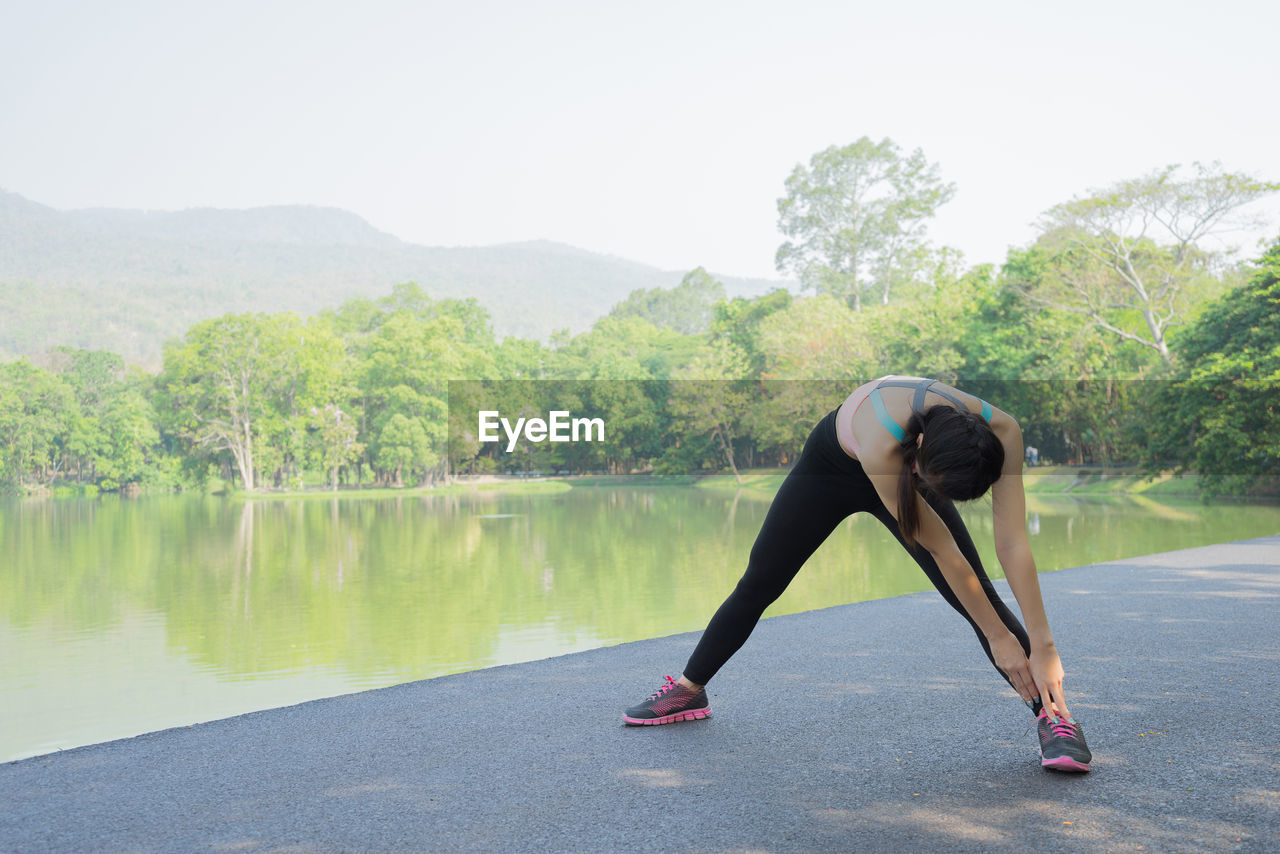 Woman stretching by lake