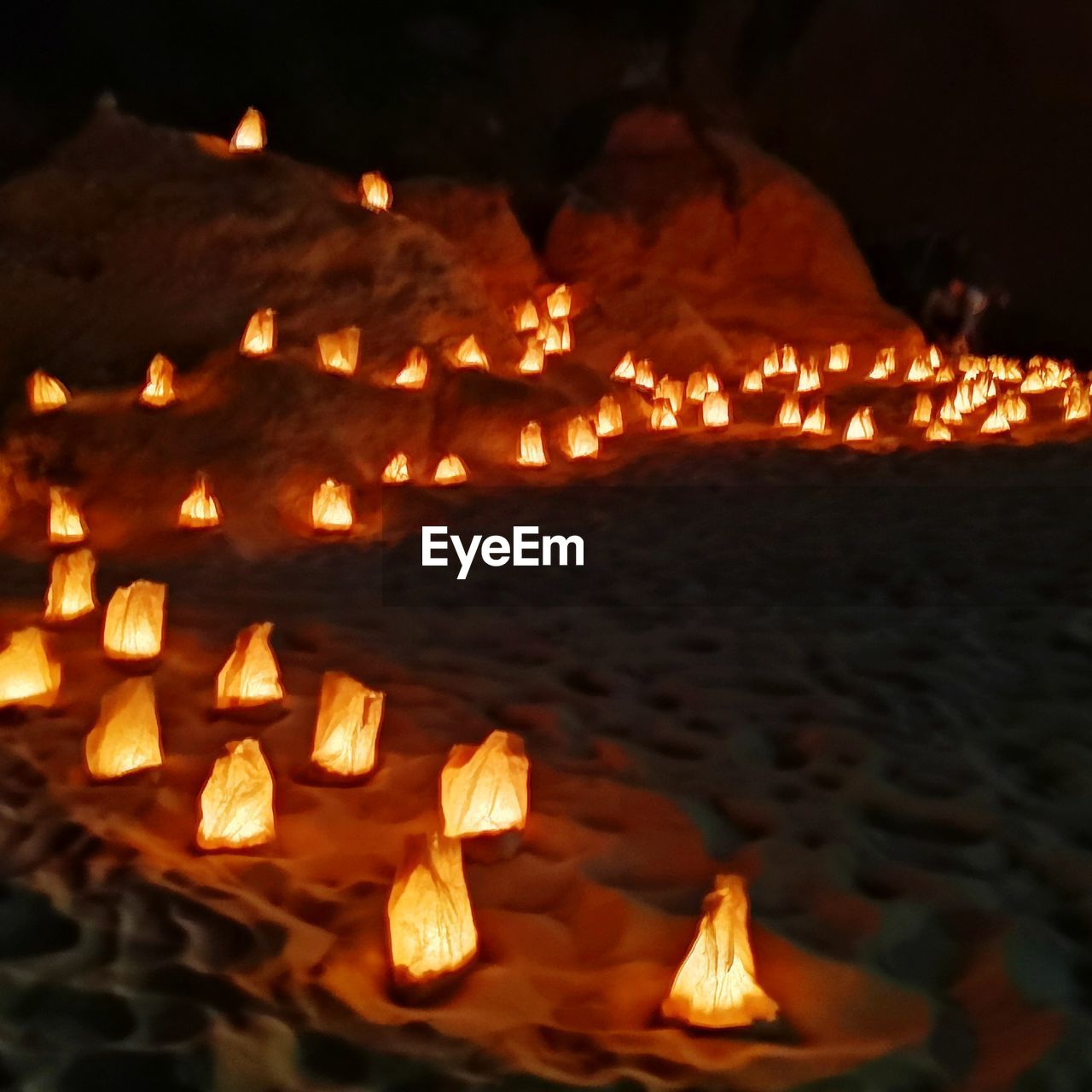 CLOSE-UP OF ILLUMINATED BURNING CANDLES