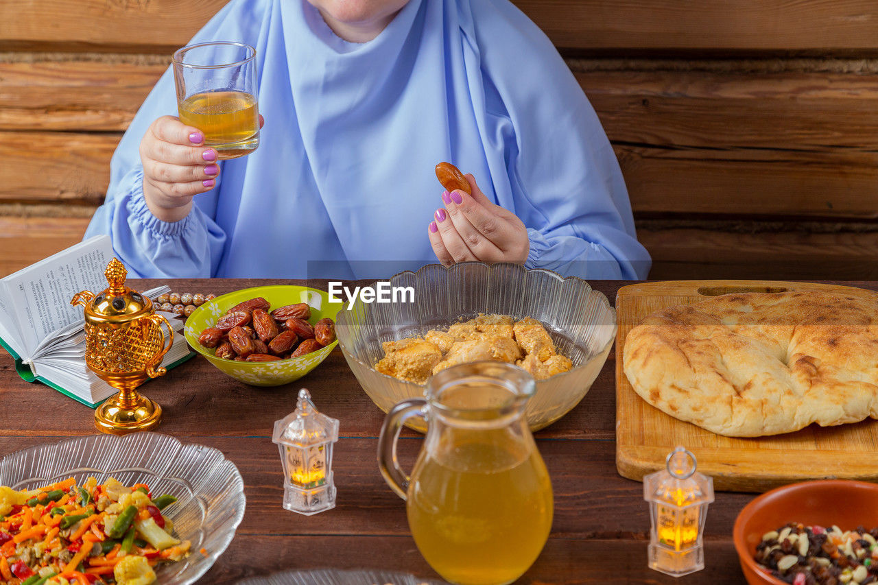 midsection of woman having food on table