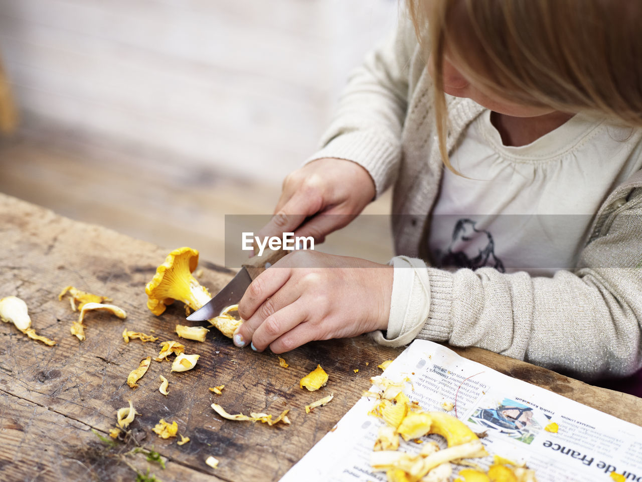 Girl cutting chanterelle, close-up