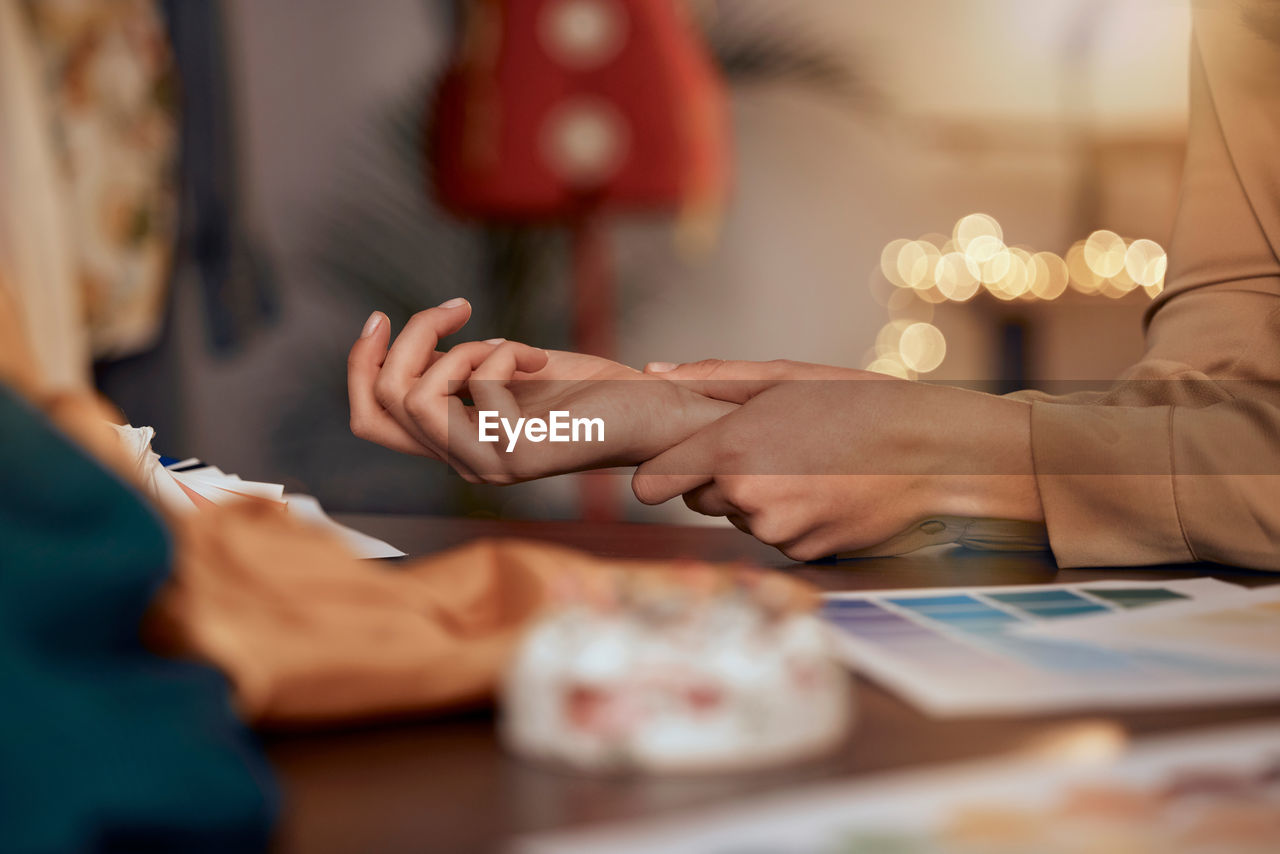 cropped hands of woman using laptop on table