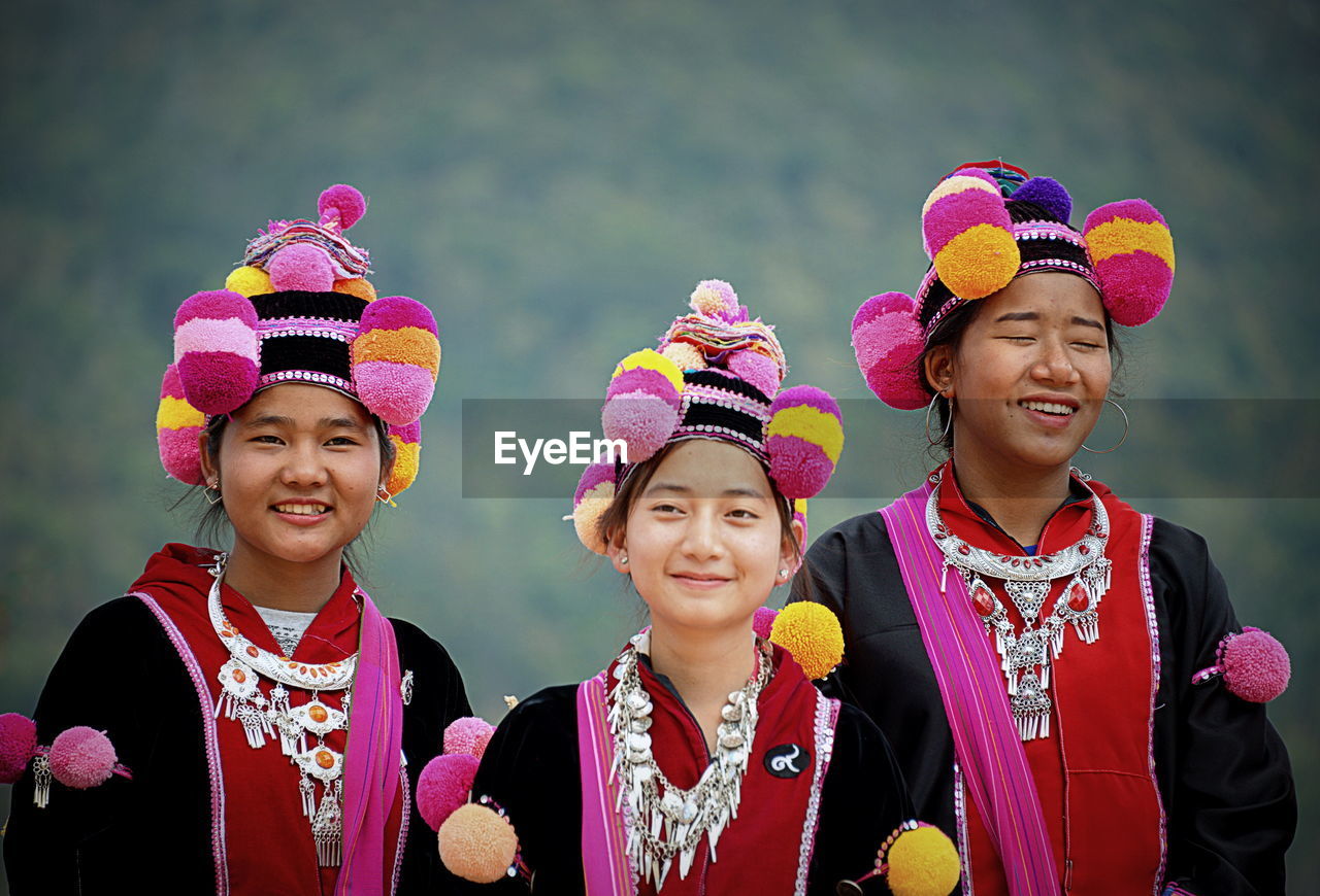 Portrait of smiling women in traditional clothing while standing outdoors