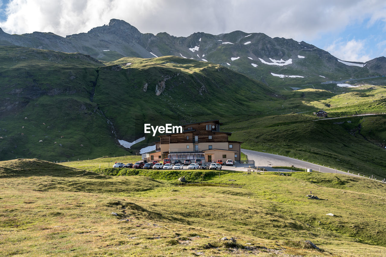 Houses on field by mountain against sky