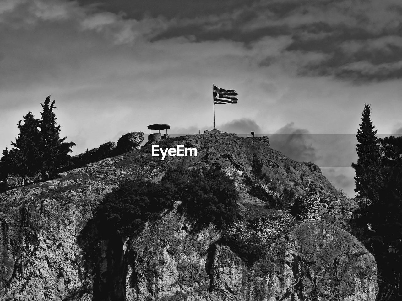 LOW ANGLE VIEW OF FLAG AGAINST ROCK FORMATION