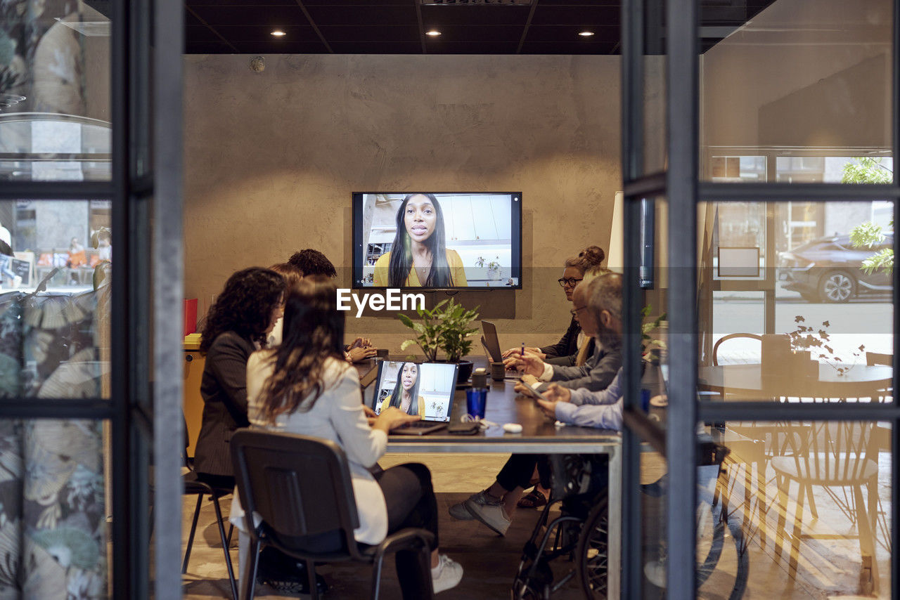 Multiracial business team discussing through virtual meeting at creative office