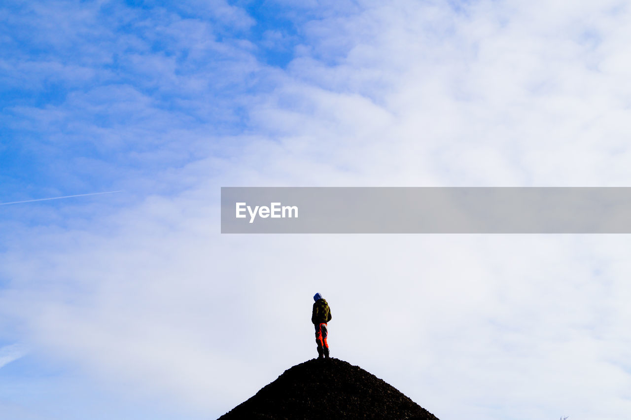 Low angle view of man on top of mountain