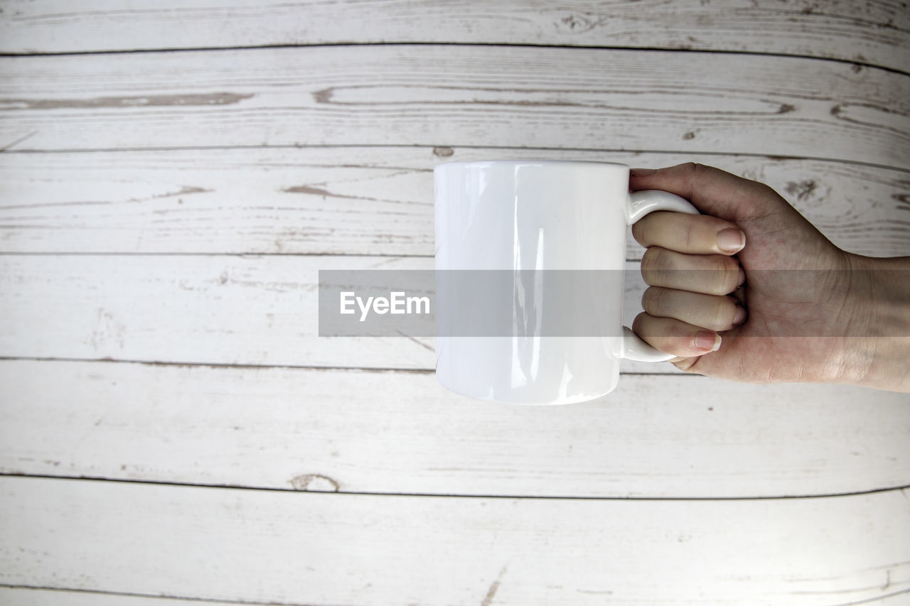 white, hand, wood, one person, food and drink, drink, cup, refreshment, holding, adult, indoors, mug, close-up, lifestyles, table, coffee cup, coffee, day, men, food, lighting