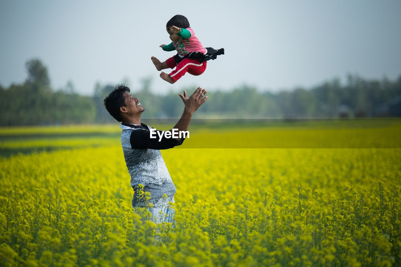 FULL LENGTH OF FATHER AND SON IN FIELD