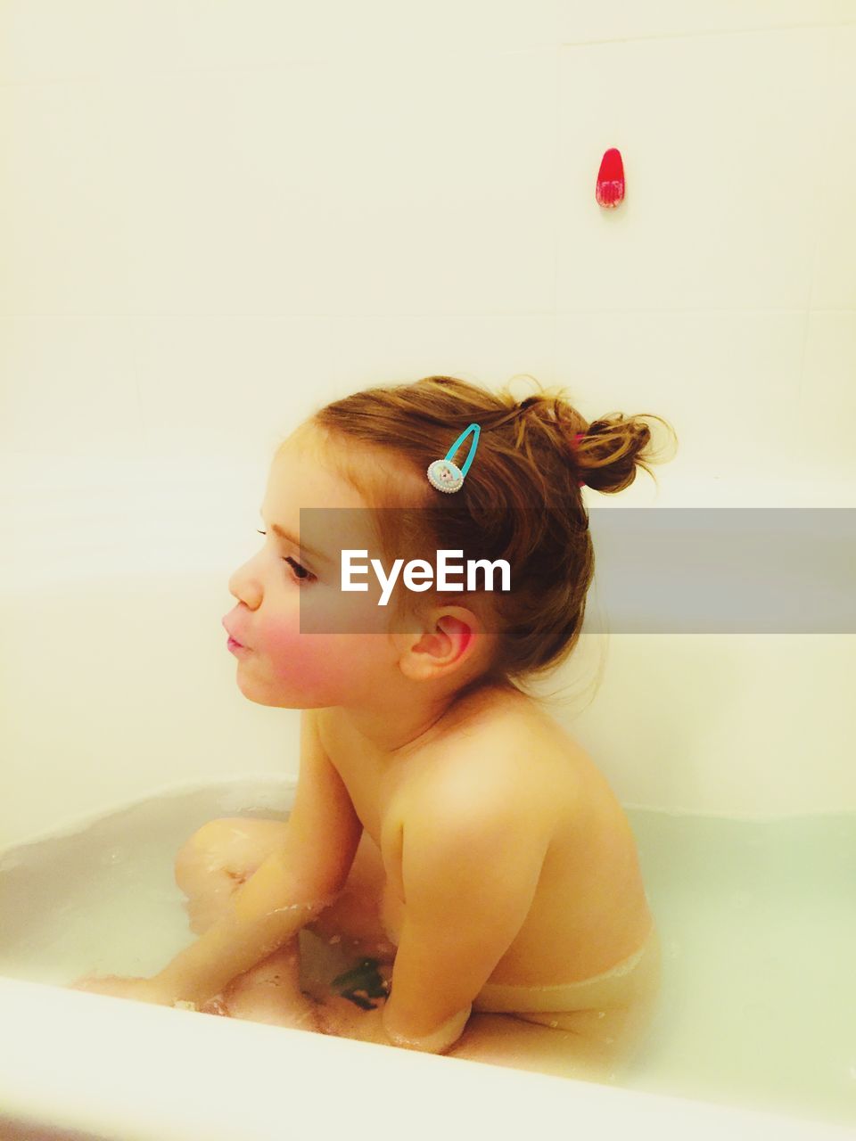 CLOSE-UP OF BABY GIRL IN BATHTUB