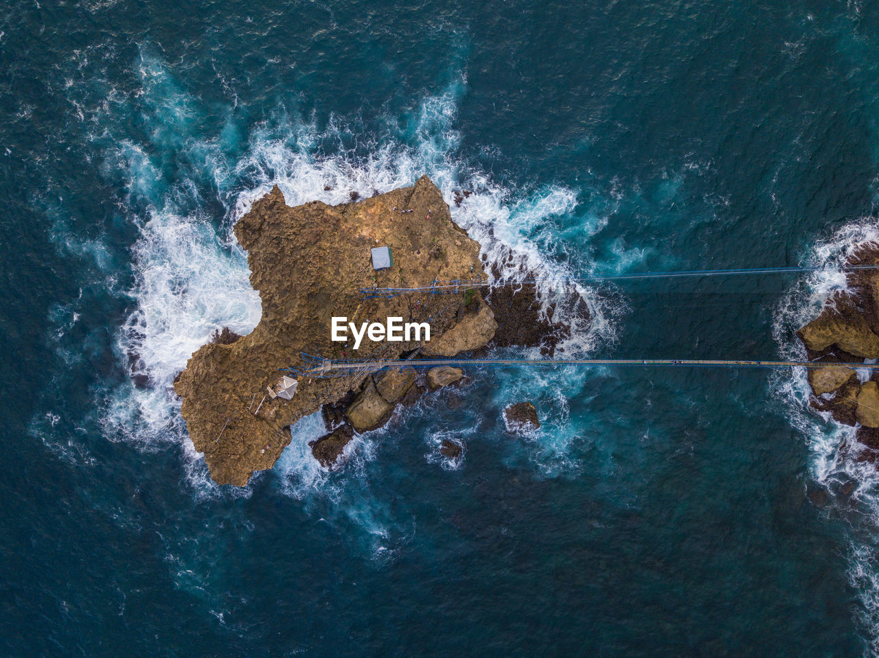 HIGH ANGLE VIEW OF SEA WAVES SPLASHING ON ROCK