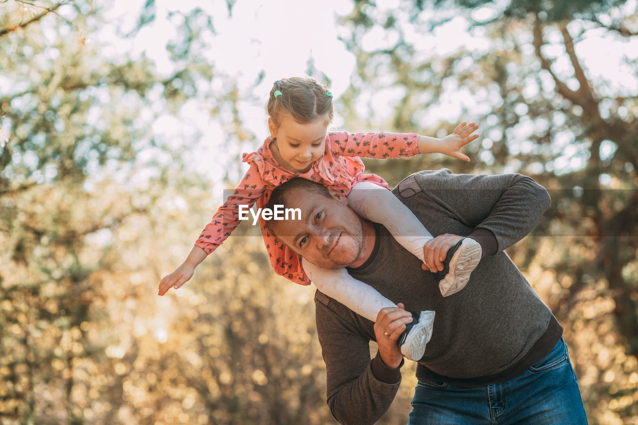 Happy father and child having fun playing outdoors. smiling dad and daughter spending time together 