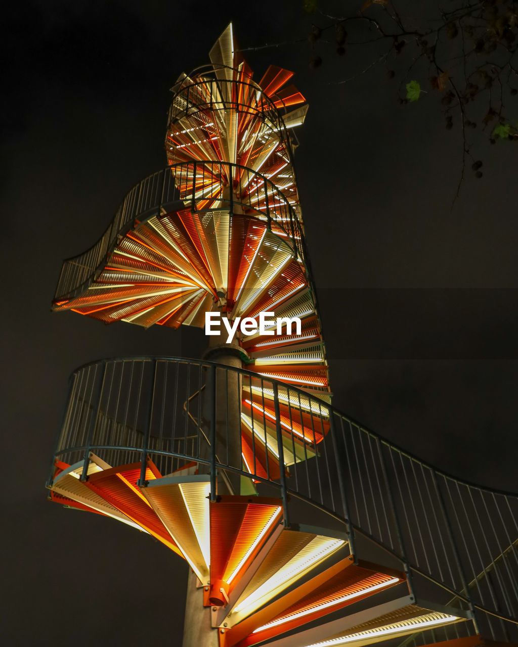 Low angle view of illuminated staircases against sky at night