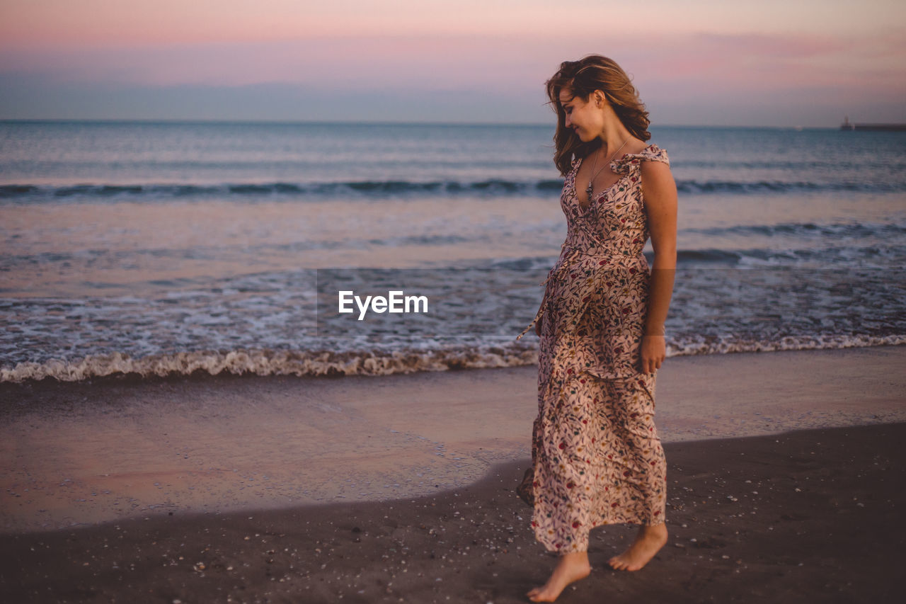 Full length of woman at beach during sunset