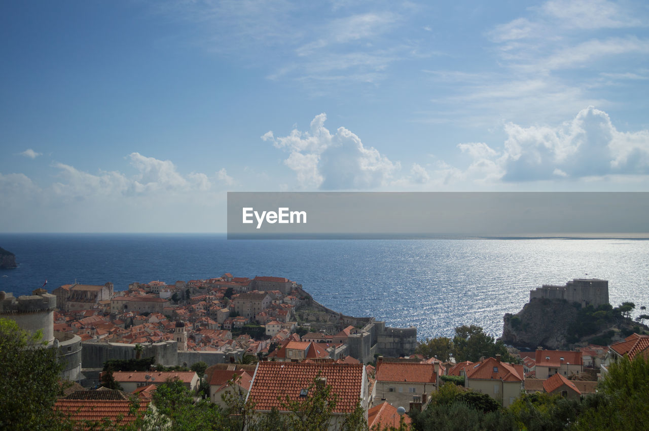 Scenic view of sea and houses against sky