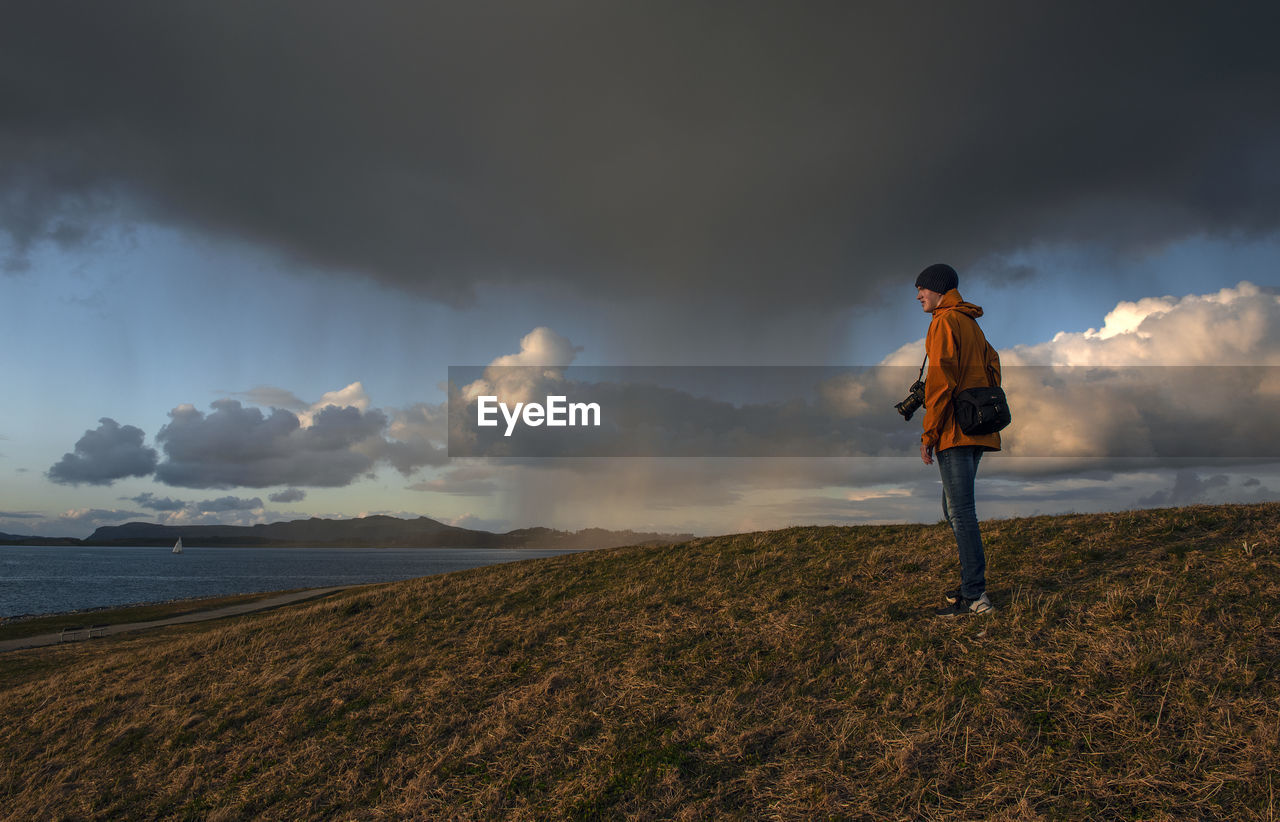 Rear view of man standing on land against sky