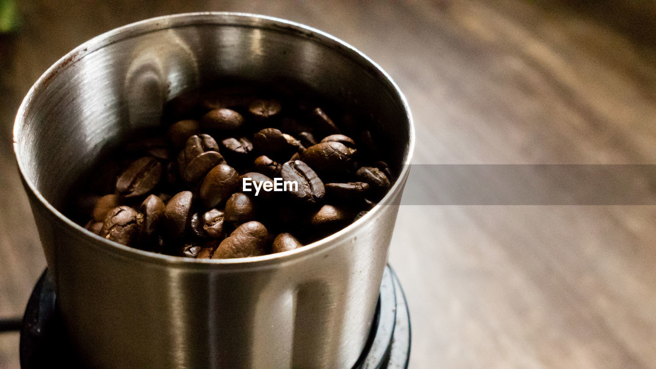 High angle view of roasted coffee beans in container on table