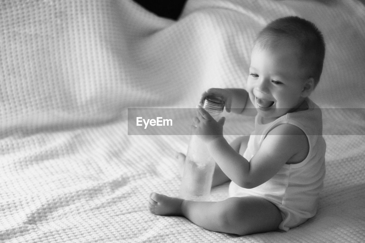 Cute baby boy sitting on bed at sleep time