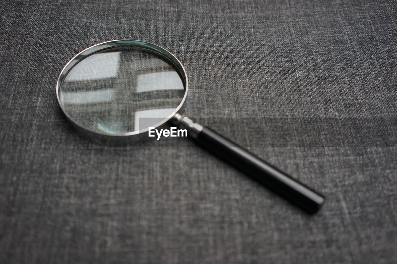 High angle view of magnifying glass on table