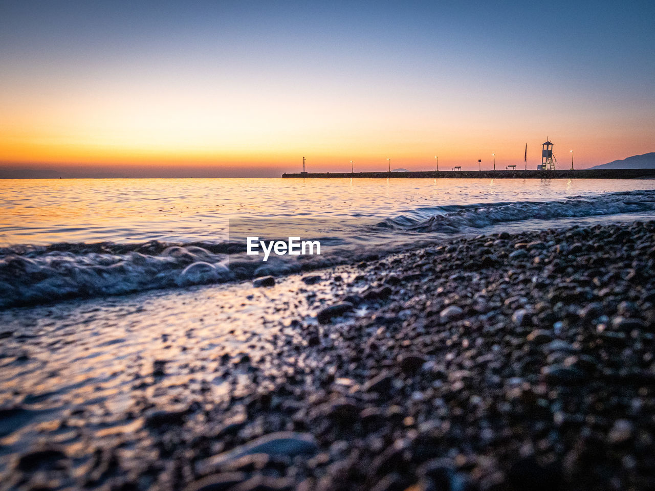 SCENIC VIEW OF BEACH AGAINST SKY DURING SUNSET