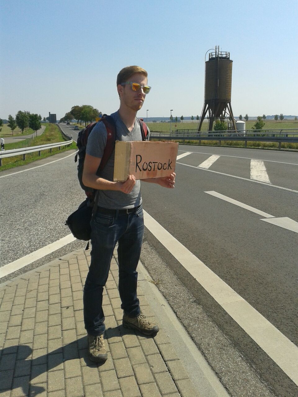 Young man holding sign while standing on street