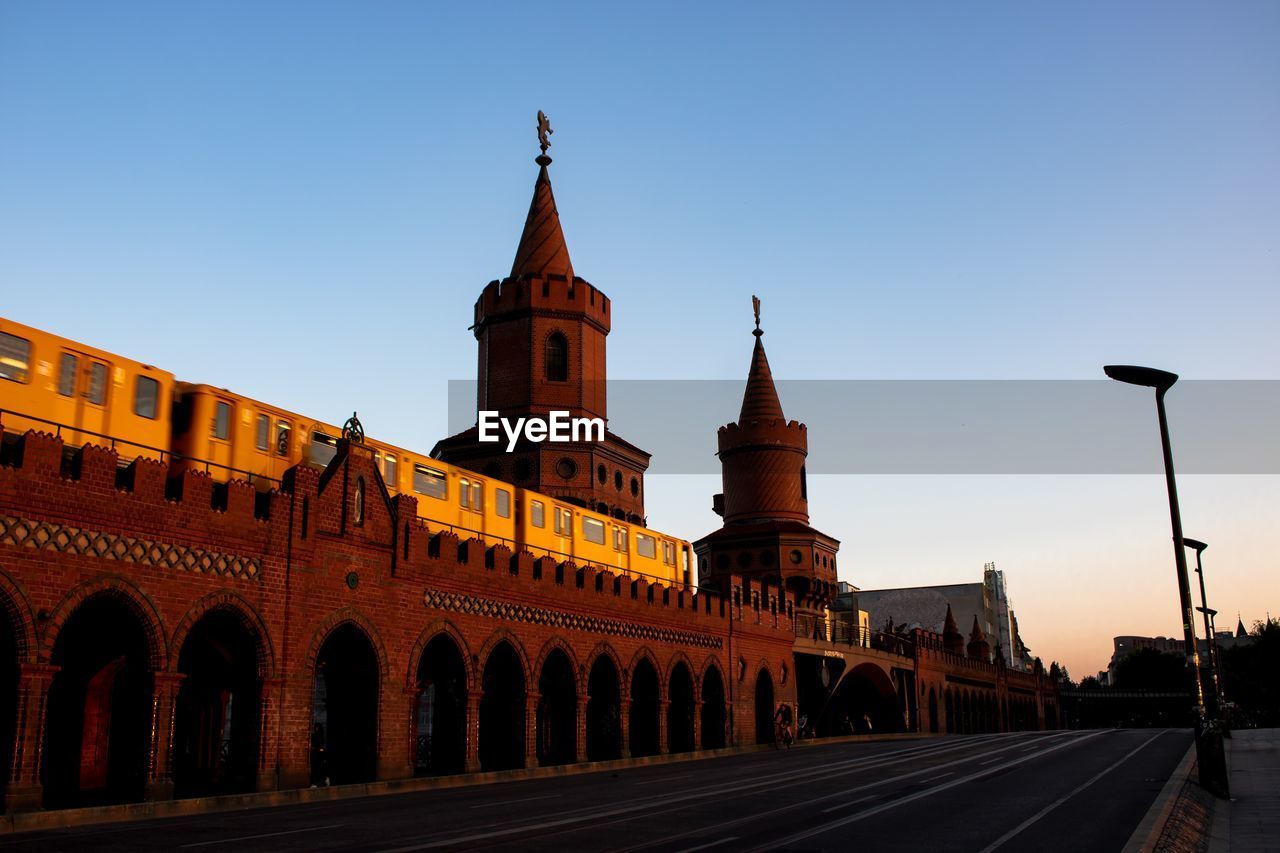 Street by buildings against clear sky