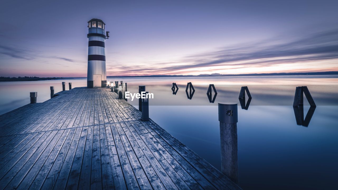 Lighthouse against sea at dusk