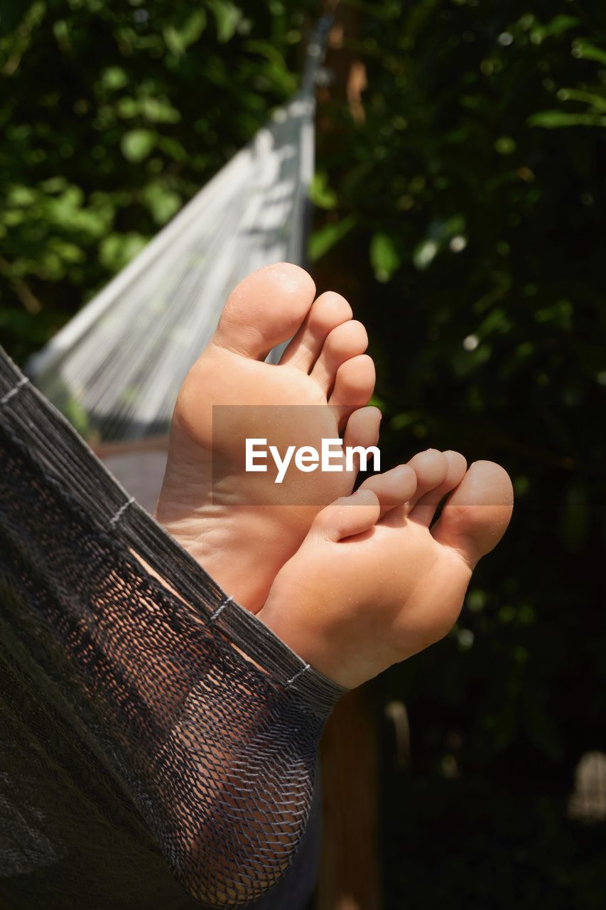Close-up of bare feet in hammock