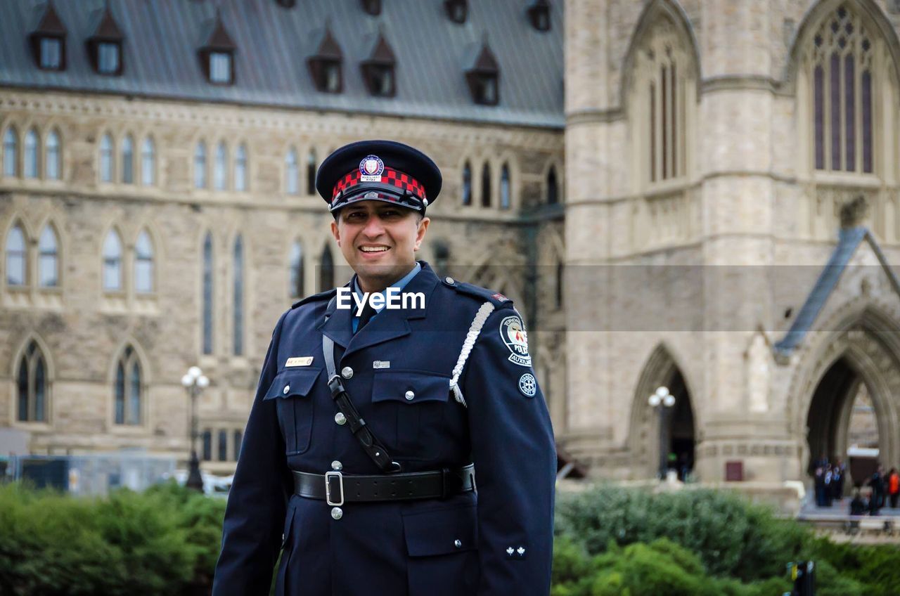 Portrait of smiling man standing against historic building 