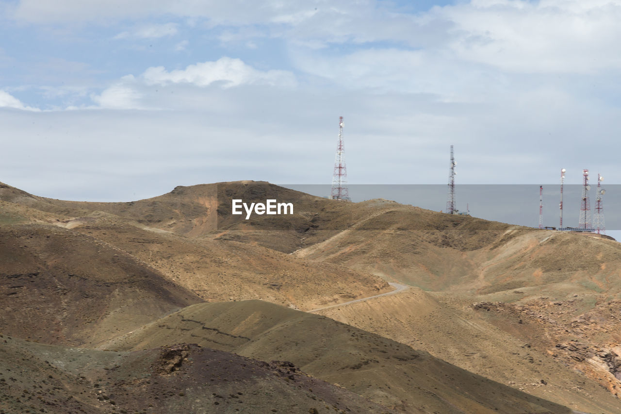 LOW ANGLE VIEW OF SMOKE STACK ON MOUNTAIN AGAINST SKY