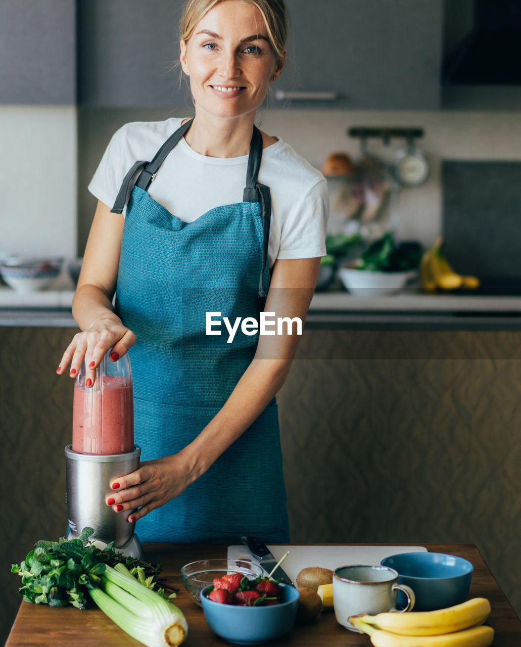 Mid adult woman preparing food on table at home