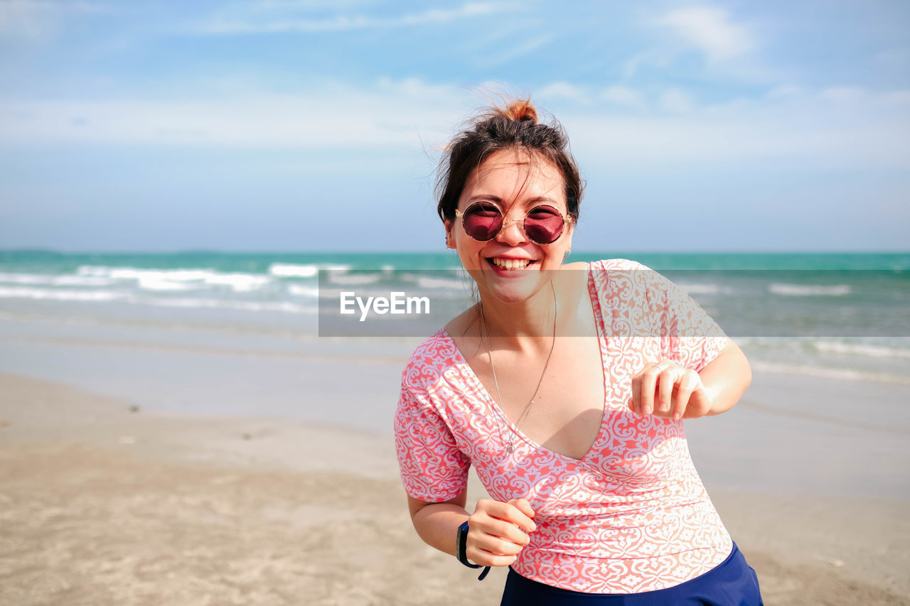 Young asian woman in a cute dress is relaxing at the beach.