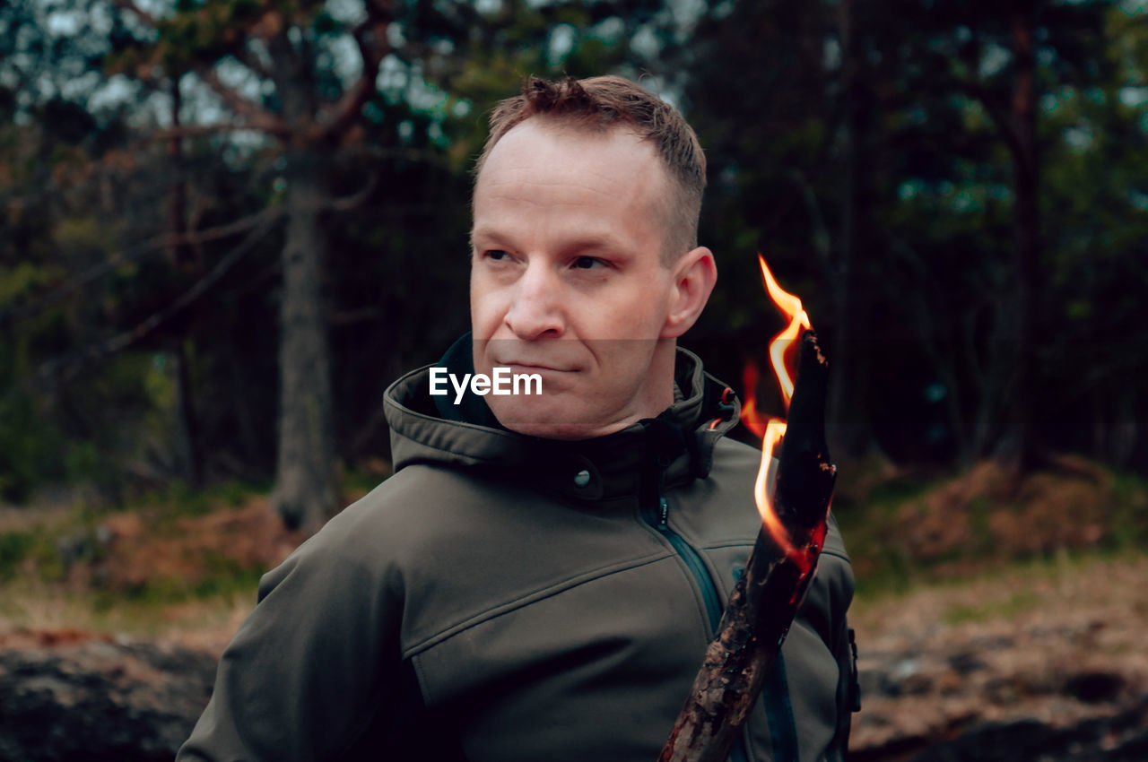 Portrait of man standing in forest