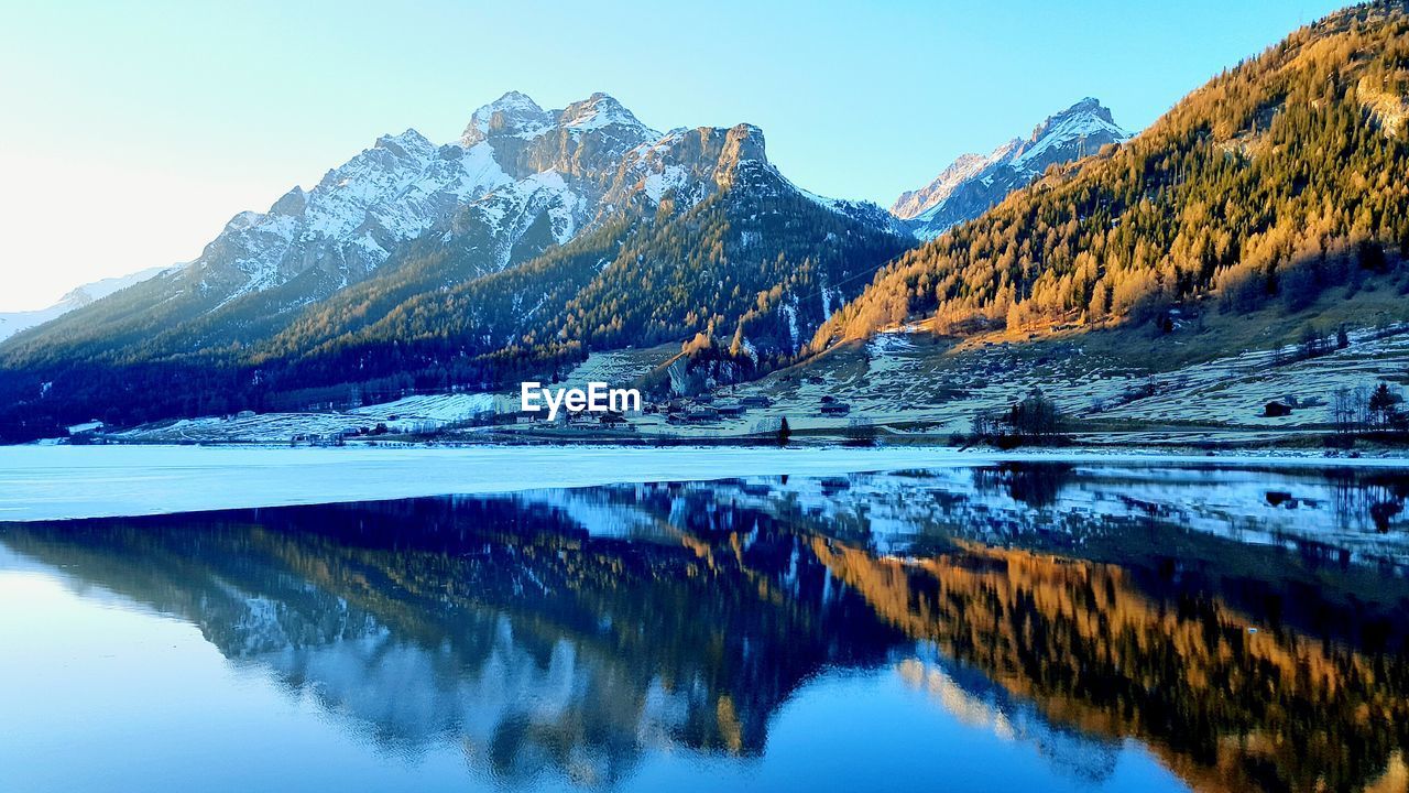 Idyllic shot of mountains reflection in lake against sky