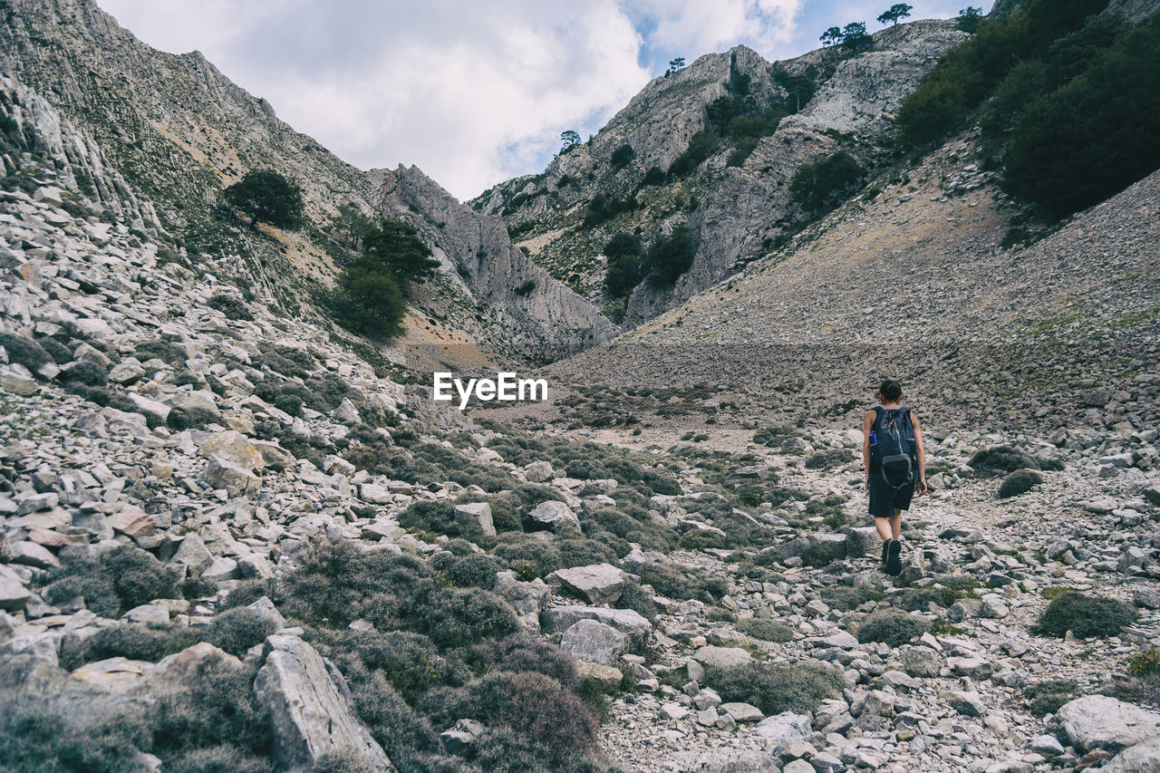 Woman hiking on a mountain path in catalonia on a cloudy summer day