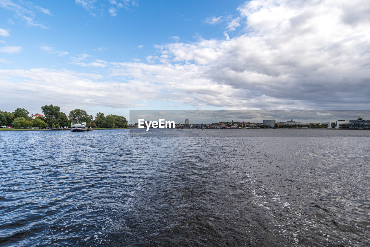 SCENIC VIEW OF RIVER BY CITY AGAINST SKY