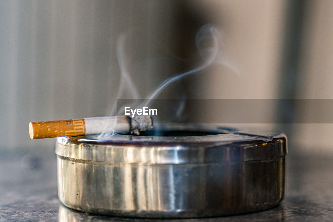 CLOSE-UP OF CIGARETTE IN CONTAINER